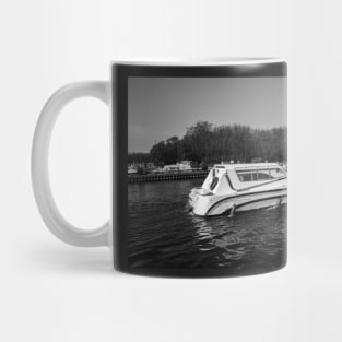 Hire boat cruising the River Bure in the village of Horning Mug